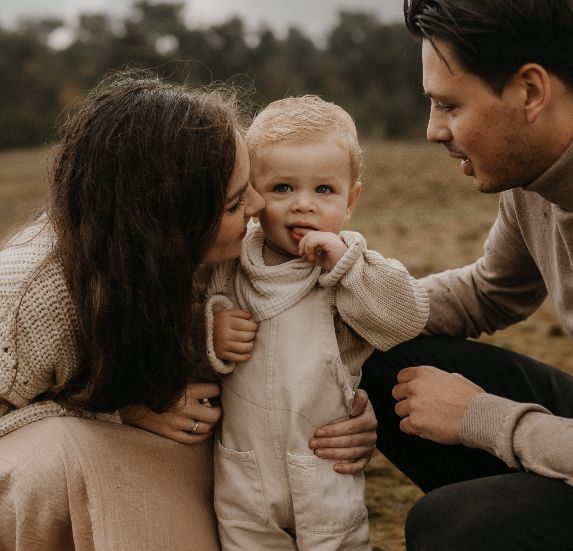 Eltern schauen ihr Kind an bei einem Familienshooting in der Natur